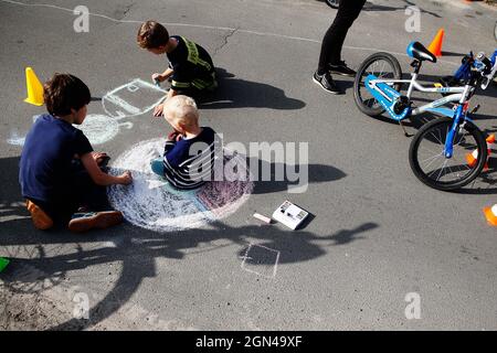 Berlin, Deutschland. September 2021. Kinder zeichnen mit Kreide auf der temporären Spielstraße Sprungschanzenweg im Stadtteil Dahlem. Am Mittwoch gibt es in allen Bezirken Berlins temporäre Spielstraßen für Kinder. Quelle: Carsten Koall/dpa/Alamy Live News Stockfoto