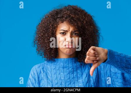 Nahaufnahme Porträt unzufrieden, düster traurig, sulking afroamerikanische Mädchen mit pouting Lippen zeigen Daumen-unten, beschweren, nicht wie weihnachtsgeschenk Stockfoto