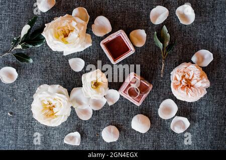 Eheringe in einer Schachtel auf einem Blumenhintergrund. Layout. Draufsicht Stockfoto