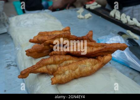 Brotbraten, ein chinesisches Frühstück, das morgens auf der Straße zum Verkauf in Territy Bazar, Kalkutta, Westbengalen, Indien, zubereitet wird. Stockfoto