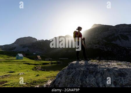 Wanderer stehen auf dem Felsen am wunderschönen Kapetanovo See bei Sonnenuntergang, Captain's Lake zwischen den Bergen hoch über niksic City in montenegro Stockfoto
