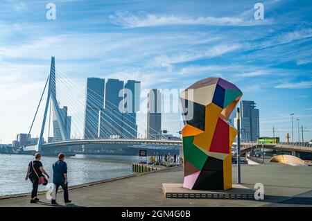 Rotterdam Niederlande - 22 2021. August; Paar, das am Wasser entlang an der farbenfrohen abstrakten Skulptur namens Marathonbeeld entlang zur Erasmusbrücke geht Stockfoto