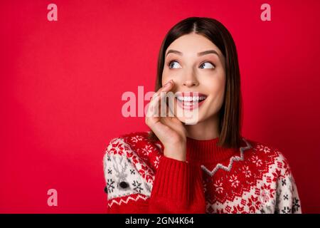 Foto von charmanten hübsche Frau gekleidet drucken Pullover Arm Lippen machen Ankündigung suchen leeren Raum isoliert roten Hintergrund Stockfoto