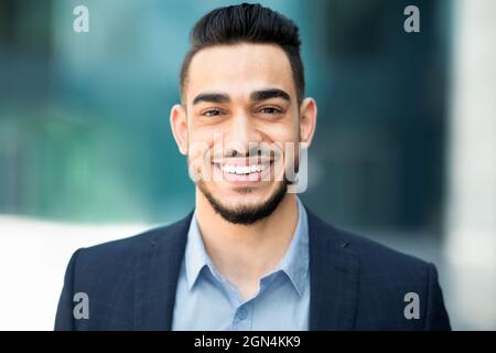 Nahaufnahme Porträt eines glücklichen jungen Geschäftsmannes aus dem Nahen Osten Stockfoto