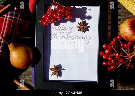 Handschriftliche Glückwünsche zum Thanksgiving Day-Gruß in einem Rahmen zwischen herbstlichem Gemüse: dahlien, Birne, Zimtstangen und Viburnum. Hochwertige Fotos Stockfoto