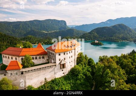 Luftaufnahme der mittelalterlichen Burg von Bled auf der Klippe des Berges unter dem Bleder See mit türkisblauem Wasser in Slowenien Stockfoto