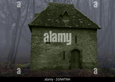 Dieses Fantasiebild eines gruseligen Hauses in einem nebligen Wald basiert auf dem Red Tower in York aus dem Jahr 1490. Stockfoto