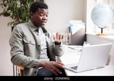 Junger Mann, Der Zu Hause Mit Gebärdensprache Auf Dem Laptop Spricht Stockfoto