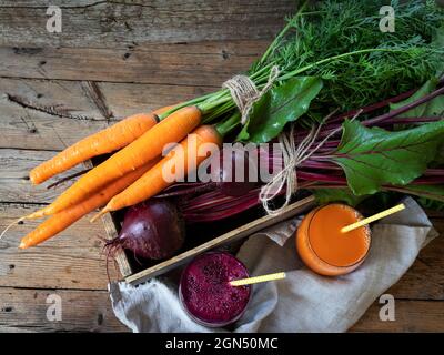 Frischer Smoothie-gepresster Rote-Bete-Karottensaft in einem Glas auf einer Holzoberfläche gesundes Essen, Entgiftung, Diät und vegetarisches Konzept. Stockfoto