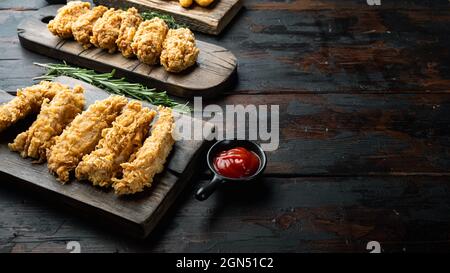 Hausgemachte knusprig gebratene Hühnerteile auf altem dunklen Holztisch mit Platz für Kopien. Stockfoto