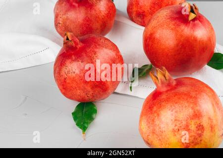 Reife Granatäpfel auf einem hellgrauen Küchentisch Stockfoto