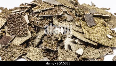 Manganproben, in der Industrie verwendetes, reines Mangan-Metall mit Flocken, isolierter weißer Hintergrund. Stockfoto
