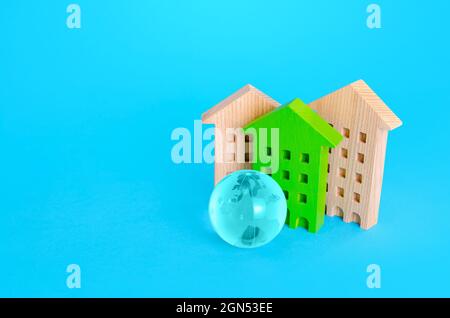 Wohngebäude und blauer Erdball. Energieeffizienz, Autonomie und Ressourcenschonung. Kommunikation und Vernetzung. Intelligente Stadt. Neues Sustainabl Stockfoto