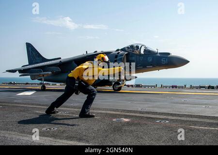 Arabisches Meer, Auf See. 19. September 2021. Ein Seemann der US-Marine signalisiert einem Marine Corps AV-8B Harrier-Kampfflugzeug, das an das Marine Attack Squadron 214 angeschlossen ist, den Start vom Flugdeck des amphibischen Sturmschiffs USS Essex der Wasp-Klasse am 19. September 2021 im Arabischen Meer. Kredit: MC3 Isaak Martinez/U.S. Navy/Alamy Live News Stockfoto