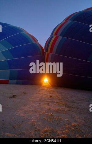 Ein Feuer, das in die Heißluftballons oder einen neu aufgeblasenen Ballon in der Morgenschwärze in der kappadokien in der Türkei gefüllt wird Stockfoto