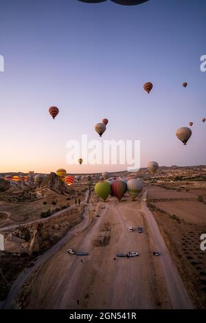 Kappadokien, Türkei - 14. September 2021: Vertikale Aufnahme von Heißluftballons, die am frühen Morgen über den goreme-Nationalpark fliegen Stockfoto