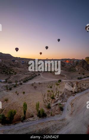 Kappadokien, Türkei - 14. September 2021: Vertikale Aufnahme von Heißluftballons, die am frühen Morgen über den goreme-Nationalpark fliegen Stockfoto