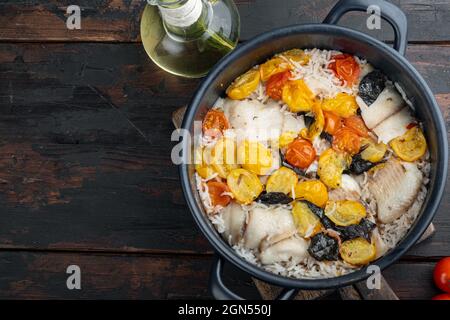 Eine Pfanne fabelhafter Fisch, mit Basmati-Reis und Kirschtomaten, auf altem Holztisch, Draufsicht mit Platz für Text Stockfoto