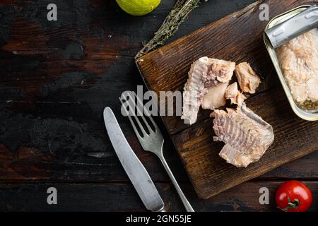 Dosen Wild Alaska Lachs Set, auf Holzschneidebrett, auf altem dunklen Holztisch Hintergrund mit Kräutern und Zutaten, Draufsicht flach, mit Copysp Stockfoto