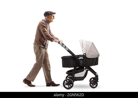 Ganzkörperaufnahme eines Großvaters, der mit einem Kinderwagen auf weißem Hintergrund läuft Stockfoto