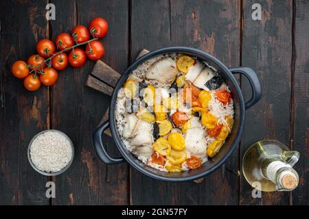 Eine Pfanne fabelhaften Fisch, mit Basmati-Reis und Kirschtomaten, auf alten Holztisch, Blick von oben Stockfoto