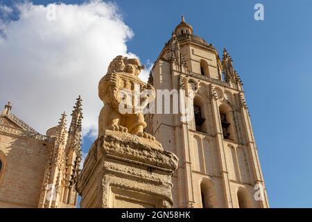 Segovia, Spanien. Skulptur eines Löwen, der das Wappen von Segovia vor dem Turm der Kathedrale unserer Lieben Frau von der Himmelfahrt und Heiligen hält Stockfoto