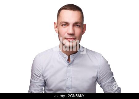 Nahaufnahme eines lächelnden, gutaussehenden Mannes, der vor weißem Hintergrund auf die Kamera schaut. Stockfoto