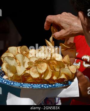 Eine Frau genießt es, auf der jährlichen Fiesta de Santa Fe in Santa Fe, New Mexico, einen Teller mit Pommes Frites oder Kartoffelchips zu essen. Stockfoto