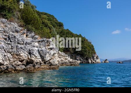 Blaues sonniges Ionisches Meer mit landschaftlich schönen grünen Felsklippen und hellem Himmel. Natur der Insel Lefkada in Griechenland. Sommerurlaub idyllisch Ormos Desimi tr Stockfoto