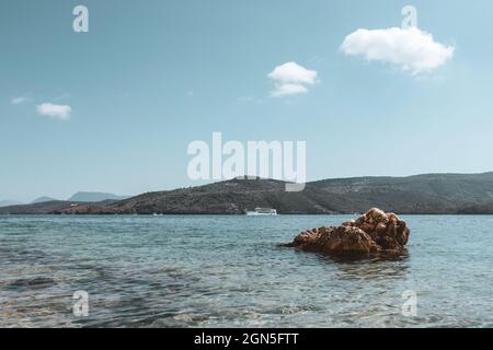 Landschaftlich schöner Blick auf den großen Felsen im blauen Ionischen Meer auf der griechischen Insel Lefkada. Segeln hellen Tag mit lebendigen Himmel und Wasser. Schiff segelt in der Ferne. Farbgrad Stockfoto