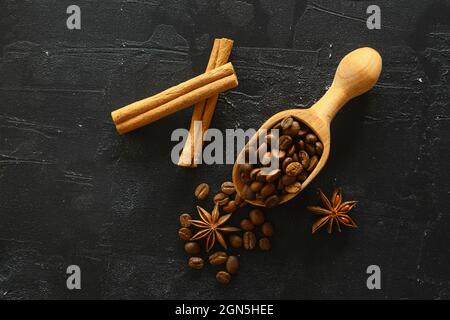 Zimtstangen und Anissterne Gewürze auf gerösteten Kaffeebohnen Hintergrund. Mit Holzschnitzelchen. Stockfoto