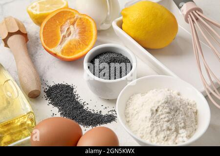 Zutaten für leckere Muffins mit Mohn auf hellem Tisch Stockfoto