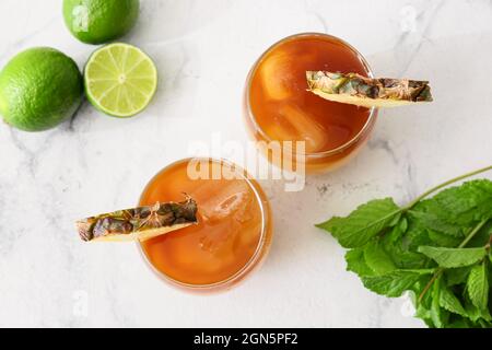 Gläser mit kaltem Mai Tai Cocktail, Minzblättern und Limette auf hellem Hintergrund Stockfoto