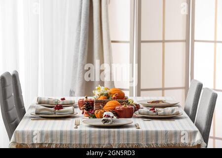 Festlich servierte Tische und wunderschöne Einrichtung im Herbst in hellem Raum Stockfoto