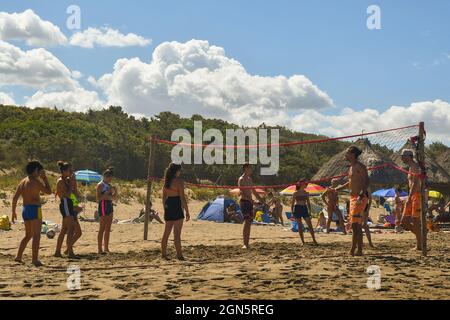 Menschen spielen Beachvolleyball am Sandstrand der toskanischen Küste der Maremma im Sommer, Marina di Castagneto Carducci, Livorno, Toskana, Italien Stockfoto