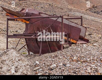 High Desert, Nevada, USA - 17. Mai 2011: Nahaufnahme eines großen rosteten Siebes, das in Hügeln aus Kieselsteinen und Felsstücken aufgestellt ist. Stockfoto