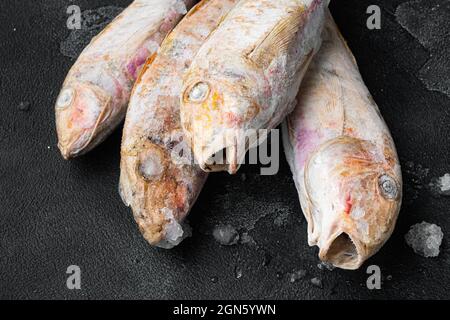 Frozen Goatfish rohes Fischset, auf schwarzem dunklen Stein Tischhintergrund Stockfoto