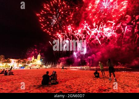 Sitges, Spanien. September 2021. Die Zuschauer versammeln sich am Strand, um dem traditionellen Feuerwerk in der Kirche San Bartolomeu während der kleinen Festa Major in Sitges, Santa Tecla, zu folgen. Die diesjährige 'Corona Edition' nahm eine sehr reduzierte Form an und ließ den Strand fast leer. Quelle: Matthias Oesterle/Alamy Live News Stockfoto