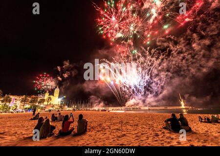 Sitges, Spanien. September 2021. Die Zuschauer versammeln sich am Strand, um dem traditionellen Feuerwerk in der Kirche San Bartolomeu während der kleinen Festa Major in Sitges, Santa Tecla, zu folgen. Die diesjährige 'Corona Edition' nahm eine sehr reduzierte Form an und ließ den Strand fast leer. Quelle: Matthias Oesterle/Alamy Live News Stockfoto