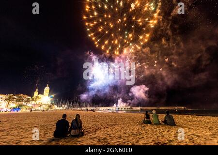 Sitges, Spanien. September 2021. Die Zuschauer versammeln sich am Strand, um dem traditionellen Feuerwerk in der Kirche San Bartolomeu während der kleinen Festa Major in Sitges, Santa Tecla, zu folgen. Die diesjährige 'Corona Edition' nahm eine sehr reduzierte Form an und ließ den Strand fast leer. Quelle: Matthias Oesterle/Alamy Live News Stockfoto