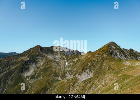 Schöne Aussicht auf die grünen felsigen Berge, die unter dem blauen Himmel glänzen Stockfoto