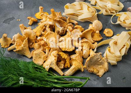 Zutaten für die Herstellung von italienischen Pasta mit Pilzen Pfifferlinge Set, auf grauem Steintisch Hintergrund Stockfoto