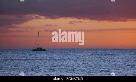 Goldener Sonnenuntergang vor der Westküste von Oahu mit Segelboot in der Ferne Stockfoto