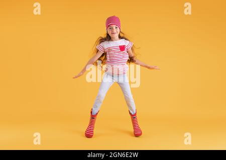 Glücklich emotionale Mädchen springen auf farbigen gelben Hintergrund. Herbst, Frühjahrssaison. Stockfoto