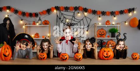 Eine Gruppe von Kindern, die als gruselige Charaktere verkleidet sind, haben Spaß auf der Halloween-Party Stockfoto