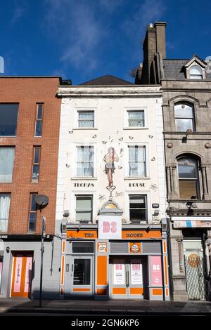 DUBLIN, IRLAND - 21. März 2021: Dublin, Irland, Blick auf die Straße einer geschlossenen Bar Thomas House mit einer Frau auf der Fassade Stockfoto