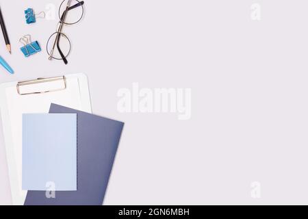 Schulbedarf auf blauem Hintergrund. Workspace-Konzept mit Ort für Text. Stockfoto