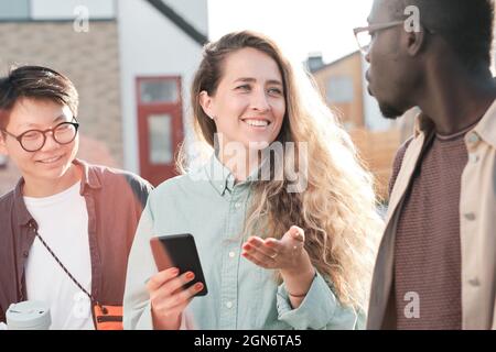 Horizontales mittleres Porträt von ethnisch unterschiedlichen Männern und Frauen, die Zeit miteinander verbringen, draußen zu gehen und über verschiedene Dinge zu reden Stockfoto