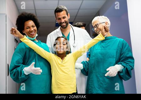Team von erfahrenen hochqualifizierten Ärzten mit Kind Patienten nach Eine erfolgreiche Behandlung Stockfoto