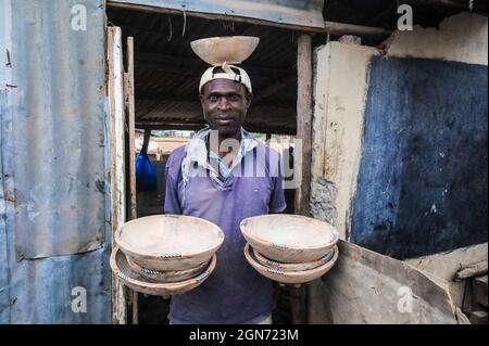 Nairobi, Kenia. September 2021. Robert Otieno (35) hält seine handgefertigten Schalen, die mit recyceltem Knochenschmuck entworfen wurden, in ihrer Werkstatt in den Slums von Kibera in Nairobi.Eine Gruppe von Handwerkern des African Bone Craft in den Slums von NairobiÃ-s Kibera verwendet recycelte Tierknochen, Hörner und Messingmetalle, um handgemachten Schmuck und Dekorationen zu kreieren, die später an Einheimische und Touristen verkauft werden, die manchmal die Werkstatt besuchen würden. Die African Bones begannen 2006 mit einer Gesamtzahl von 17 Gruppenmitgliedern, die beide vom Handwerksbetrieb abhängig sind, um ihren Lebensunterhalt zu verdienen. Sie haben trotz ch auf dem Geschäft beharrt Stockfoto